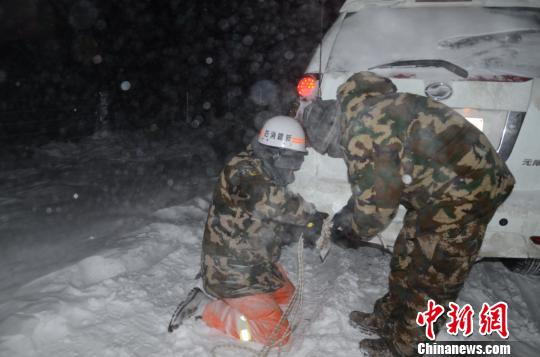圖為消防救援人員給被困車輛安裝救援繩?！±罱?攝